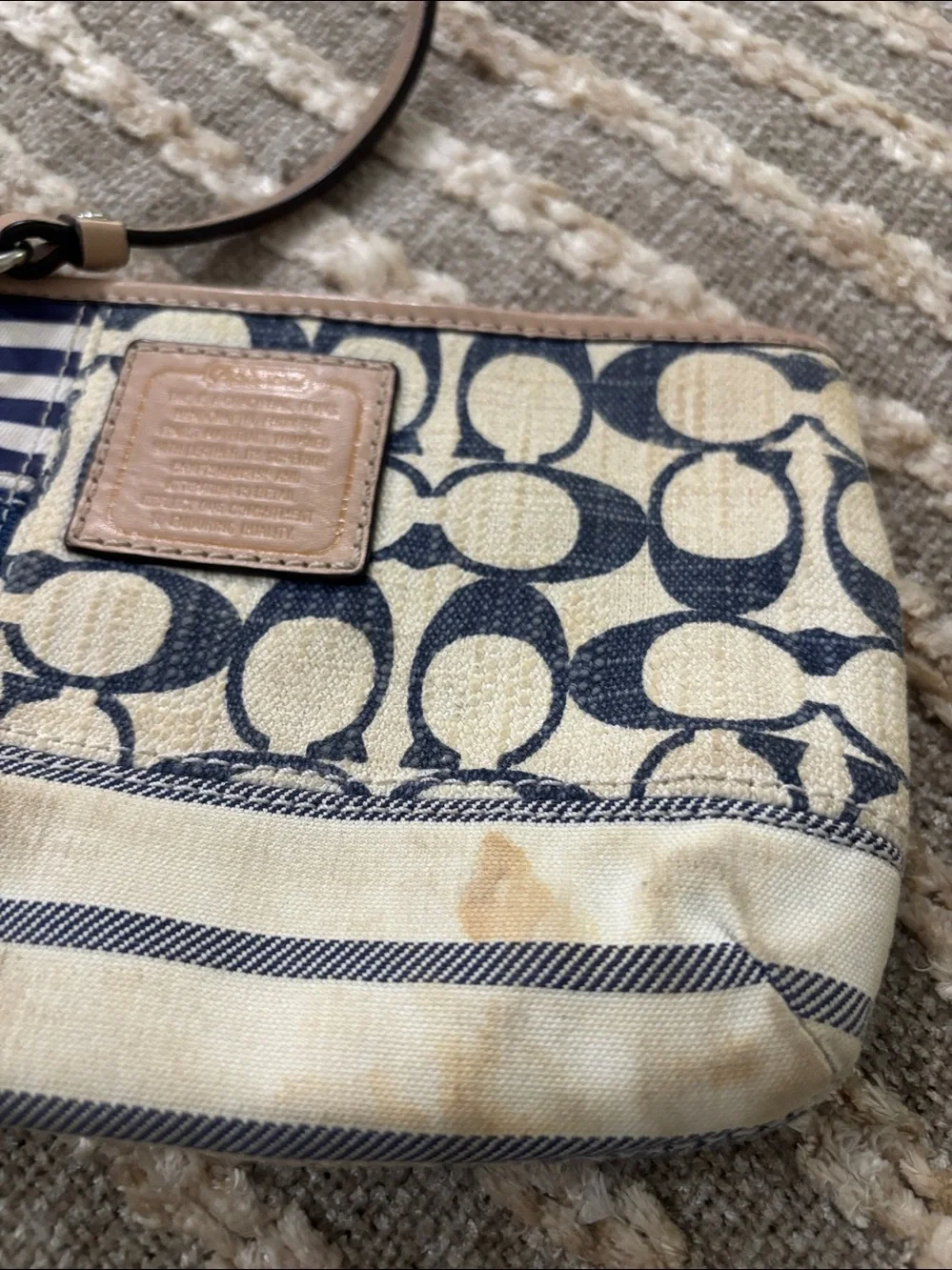 Coach wristlet featuring signature patchwork print in navy and cream